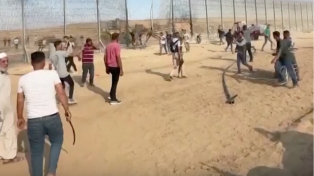 Video shows armed militants breaking through a hole in a wire fence section of the border and a bulldozer destroying part of the barrier