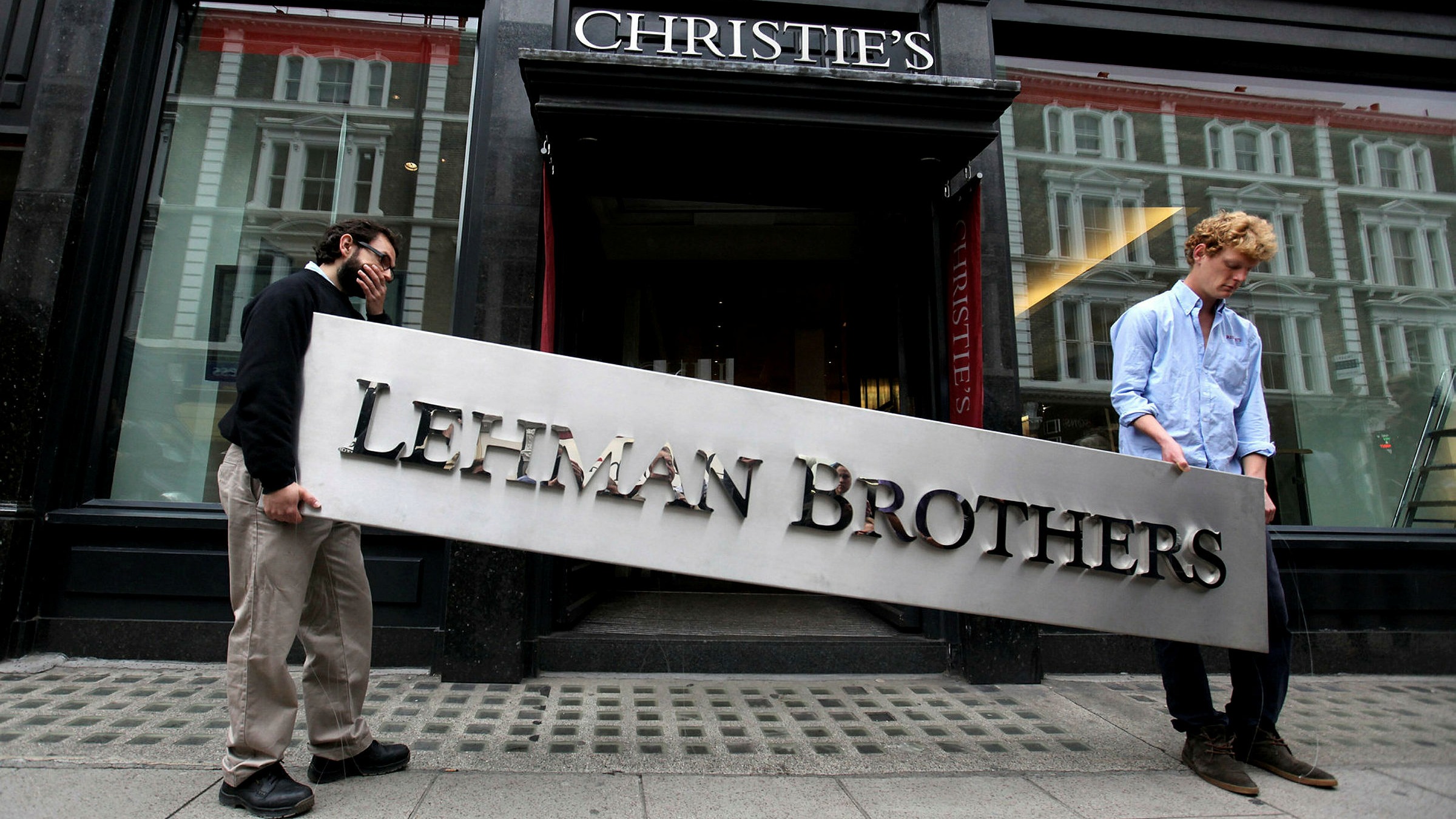 Two employees of the Lehman Brothers taking away the company sign