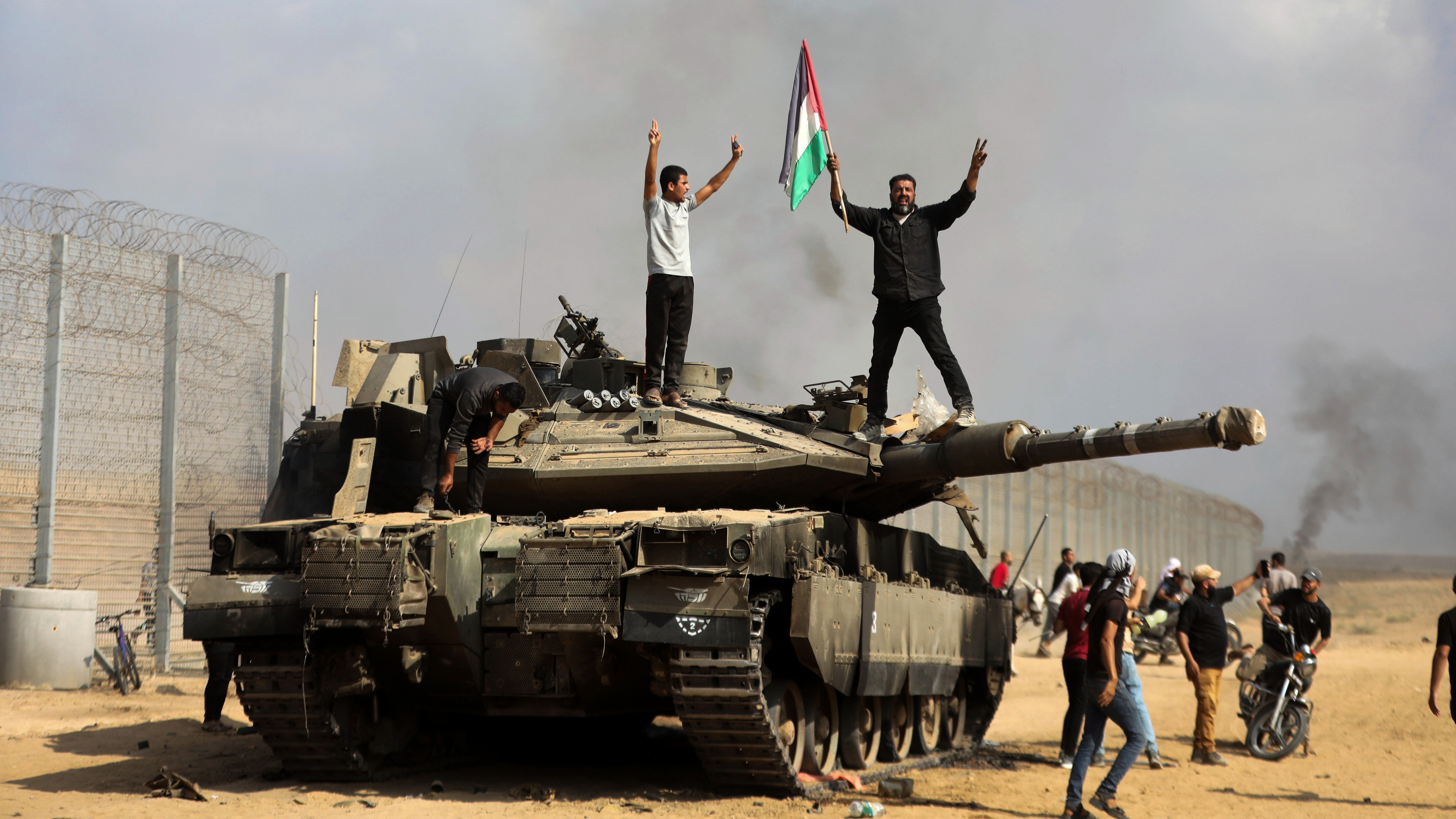 Hamas fighters on a captured Israeli tank near the Israel-Gaza border